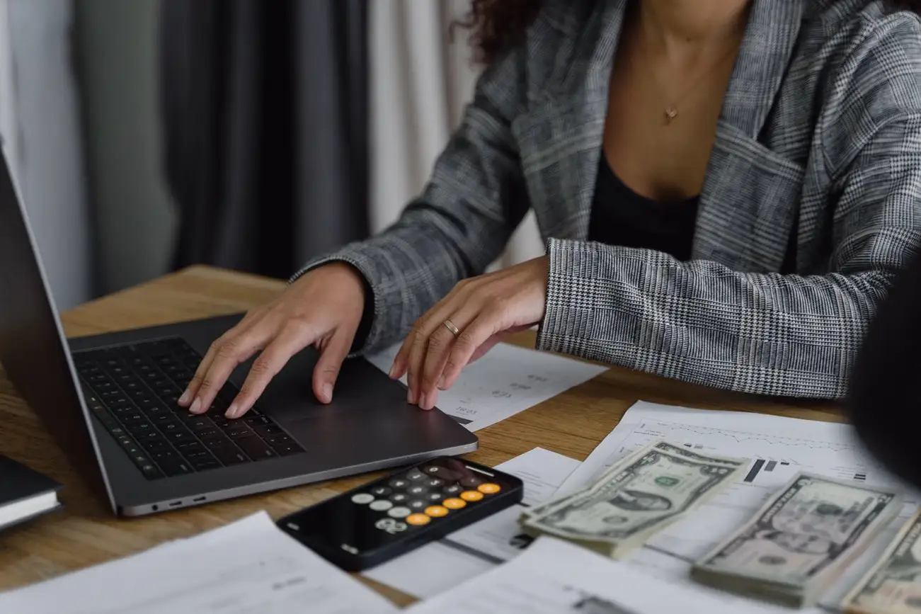 Avantages du financement : Une femme utilisant son ordinateur avec un blazer à carreaux.